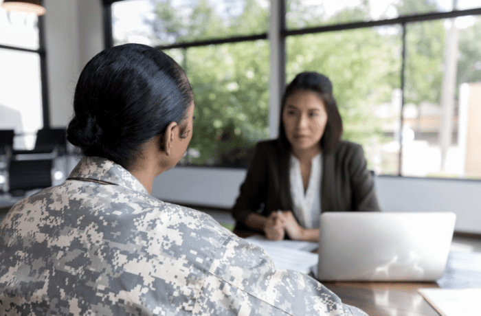 A military service woman speaking with another person.