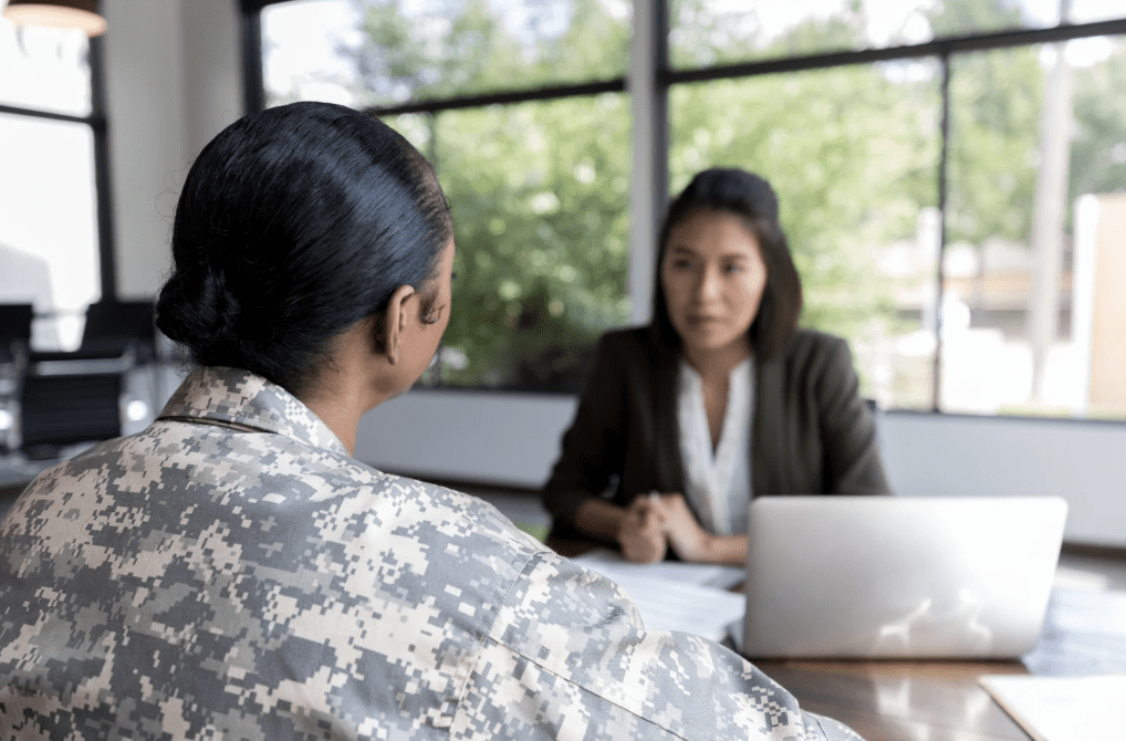 A military service woman speaking with another person.